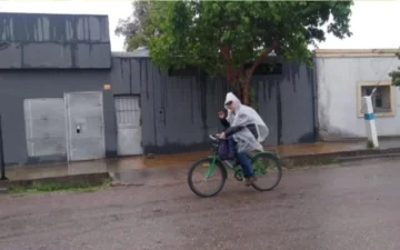 Bajo la lluvia en bicicleta, un docente sanjuanino fue a dar clases cubierto con un nailon