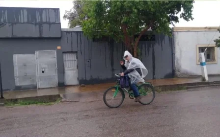 Bajo la lluvia en bicicleta, un docente sanjuanino fue a dar clases cubierto con un nailon